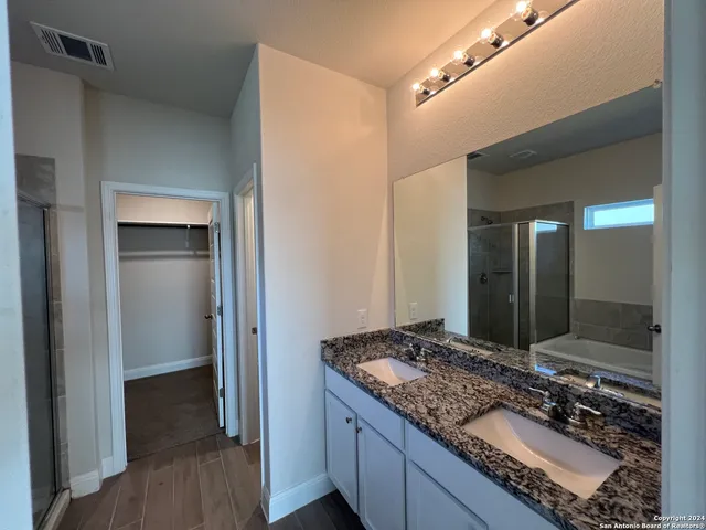 a bathroom with a granite countertop sink and a mirror