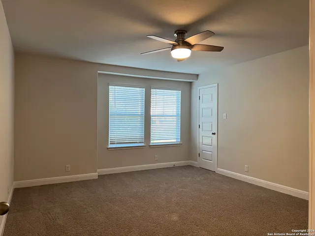 an empty room with a window and a fan
