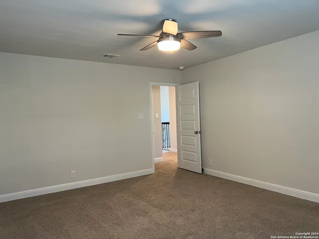 an empty room with a empty space and a ceiling fan