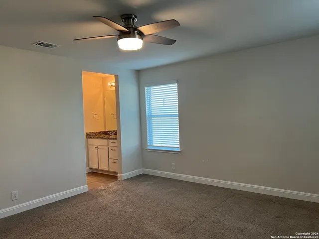 an empty room with a window and a fan