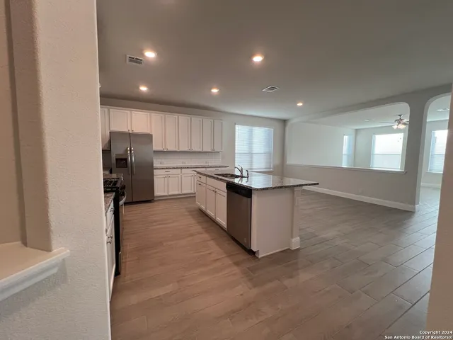 a kitchen with stainless steel appliances granite countertop a refrigerator and a sink
