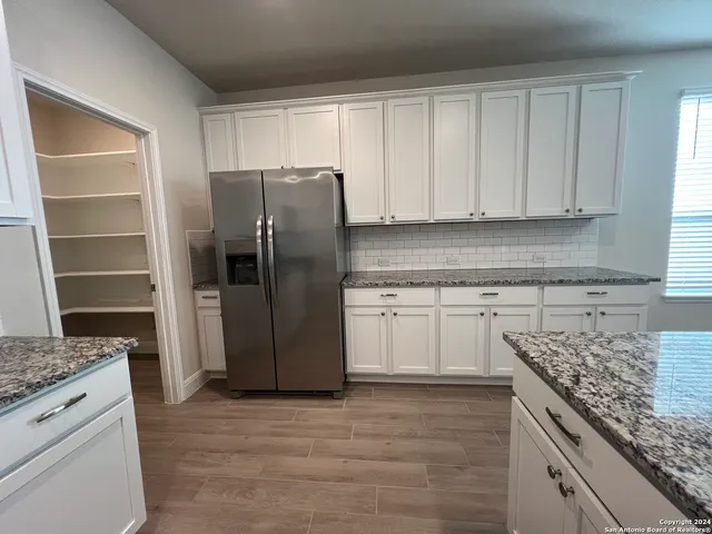 a kitchen with a refrigerator sink and cabinets