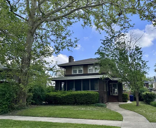 a view of a big house with a big yard and large trees