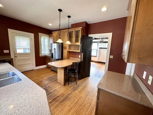 a kitchen with stainless steel appliances granite countertop wooden cabinets a stove a sink and a microwave