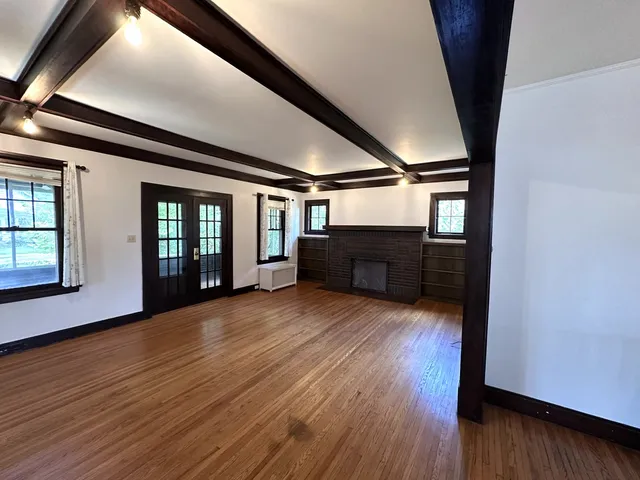 a kitchen with stainless steel appliances kitchen island granite countertop a table chairs and a wooden floor