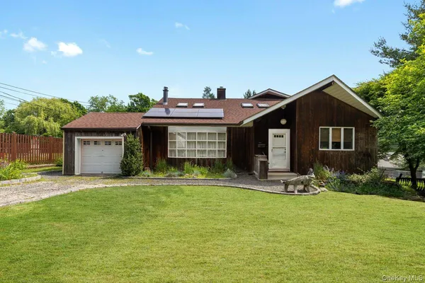 a front view of a house with a garden and trees