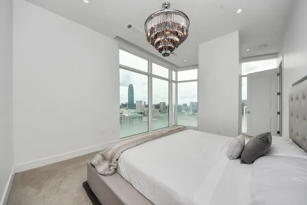 a bedroom with a large bed and a chandelier