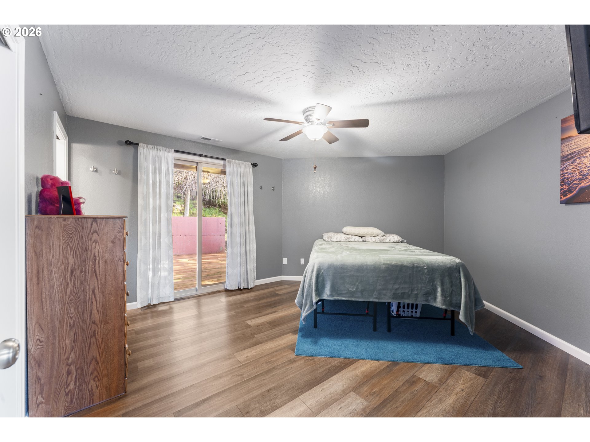 2453 Stephanie Lane North Bend, OR 97459 - Photo 15 of 48 a spacious bedroom with a bed and wooden floor