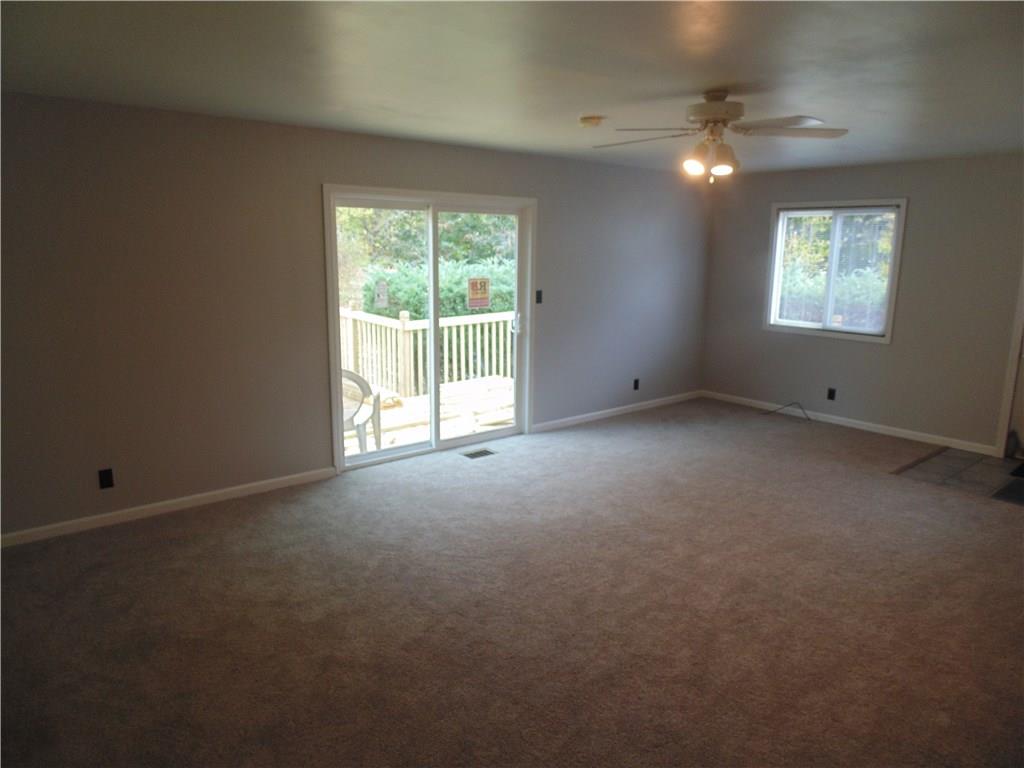 Another view of the family room with new sliding glass door, and soon to be finished re-built deck.  New blinds are present throughout 75% of the home.