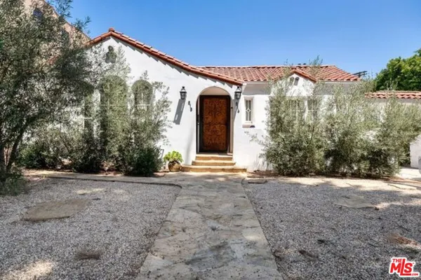 a view of a house with a yard and potted plants