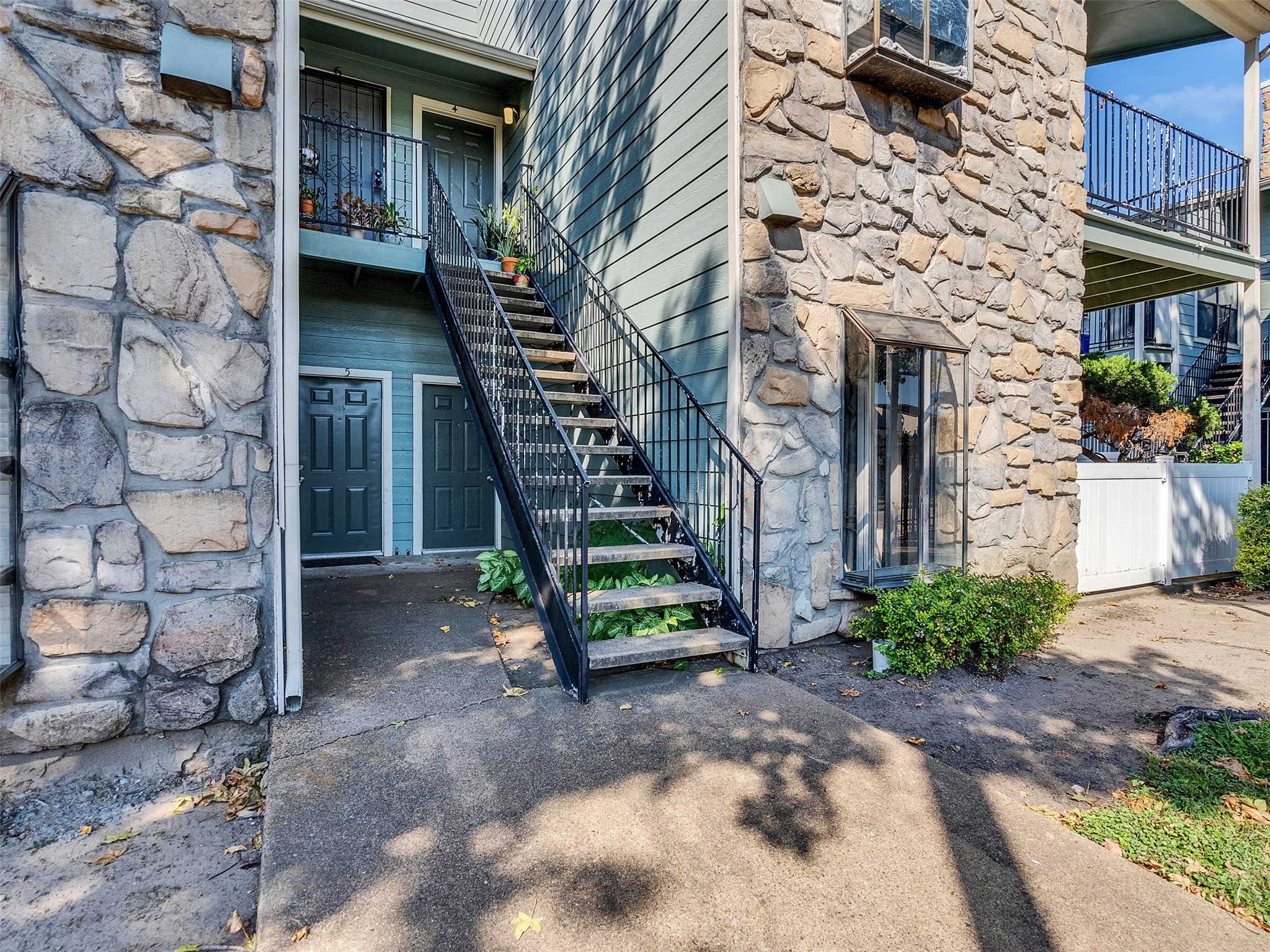 3764 Tanglewilde Street, Unit H8 Houston, TX 77063 - Photo 22 of 22 a view of a brick house with a small yard and large tree