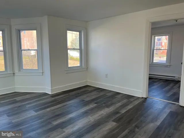 a view of empty room with wooden floor