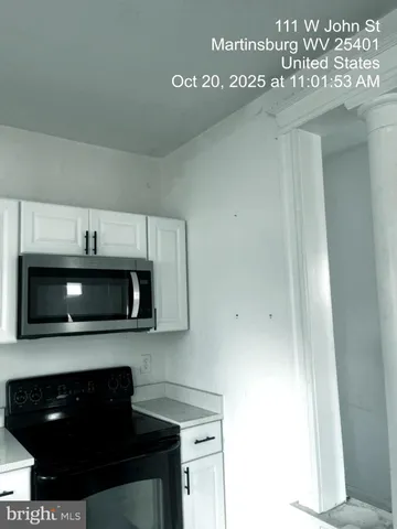 an empty room with wooden floor mirror and windows