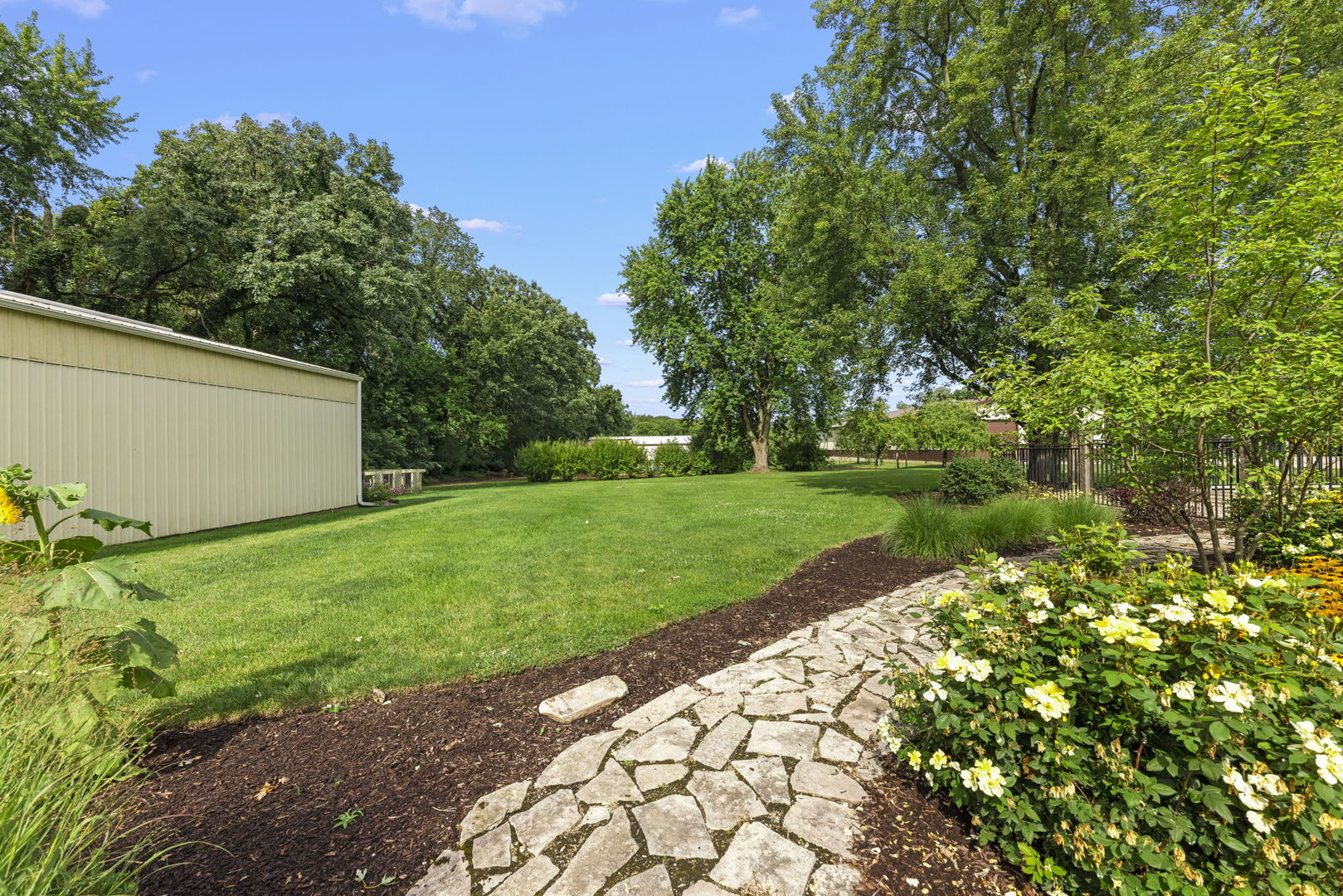 4083 West Sandwich Road Sandwich, IL 60548 - Photo 43 of 74 a view of a backyard with potted plants and large trees