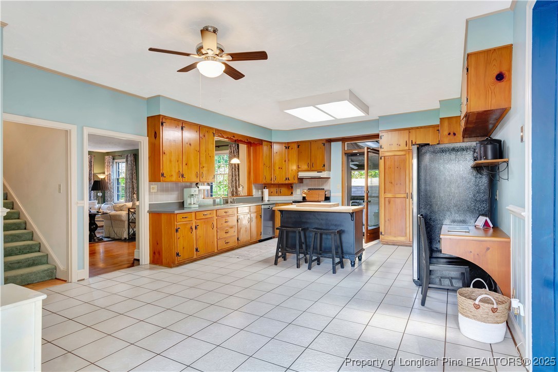 704 B T Road Lumberton, NC 28358 - Photo 12 of 45 a kitchen with stainless steel appliances kitchen island granite countertop a refrigerator a sink a dining table and chairs with wooden floor