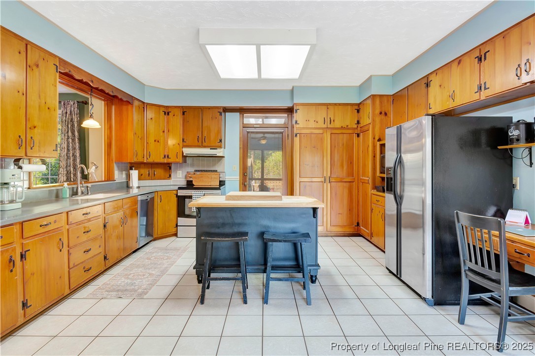 704 B T Road Lumberton, NC 28358 - Photo 13 of 45 a kitchen with stainless steel appliances granite countertop a table chairs and a refrigerator