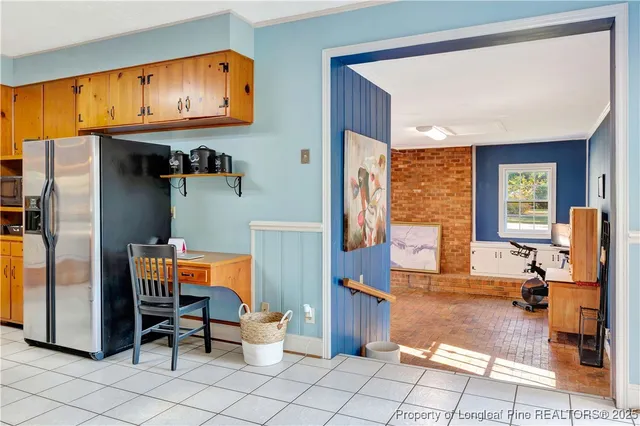 a view of kitchen with stainless steel appliances kitchen island granite countertop dining table and chairs