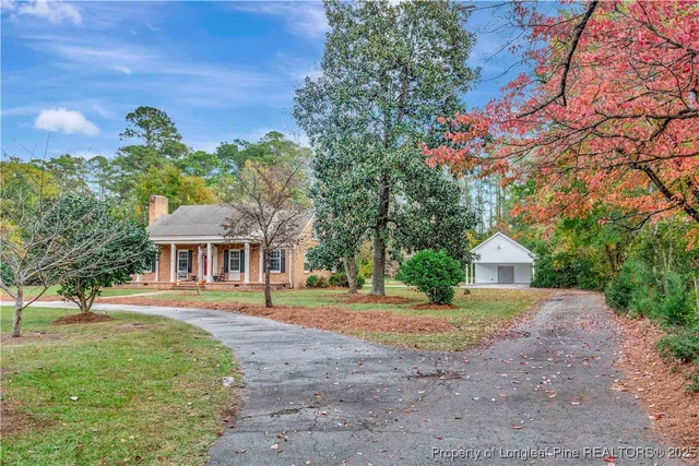 a front view of a house with a yard and trees