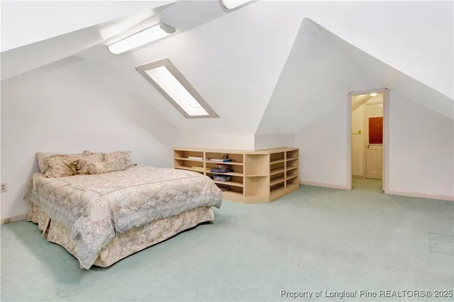 a spacious bedroom with a bed and a lamp