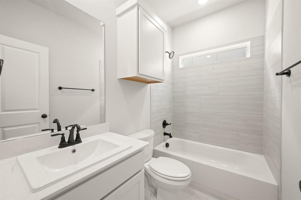 1724 Nesting Robin Lane Krum, TX 76249 - Photo 28 of 40 a bathroom with a white bath tub a sink a toilet and a shower