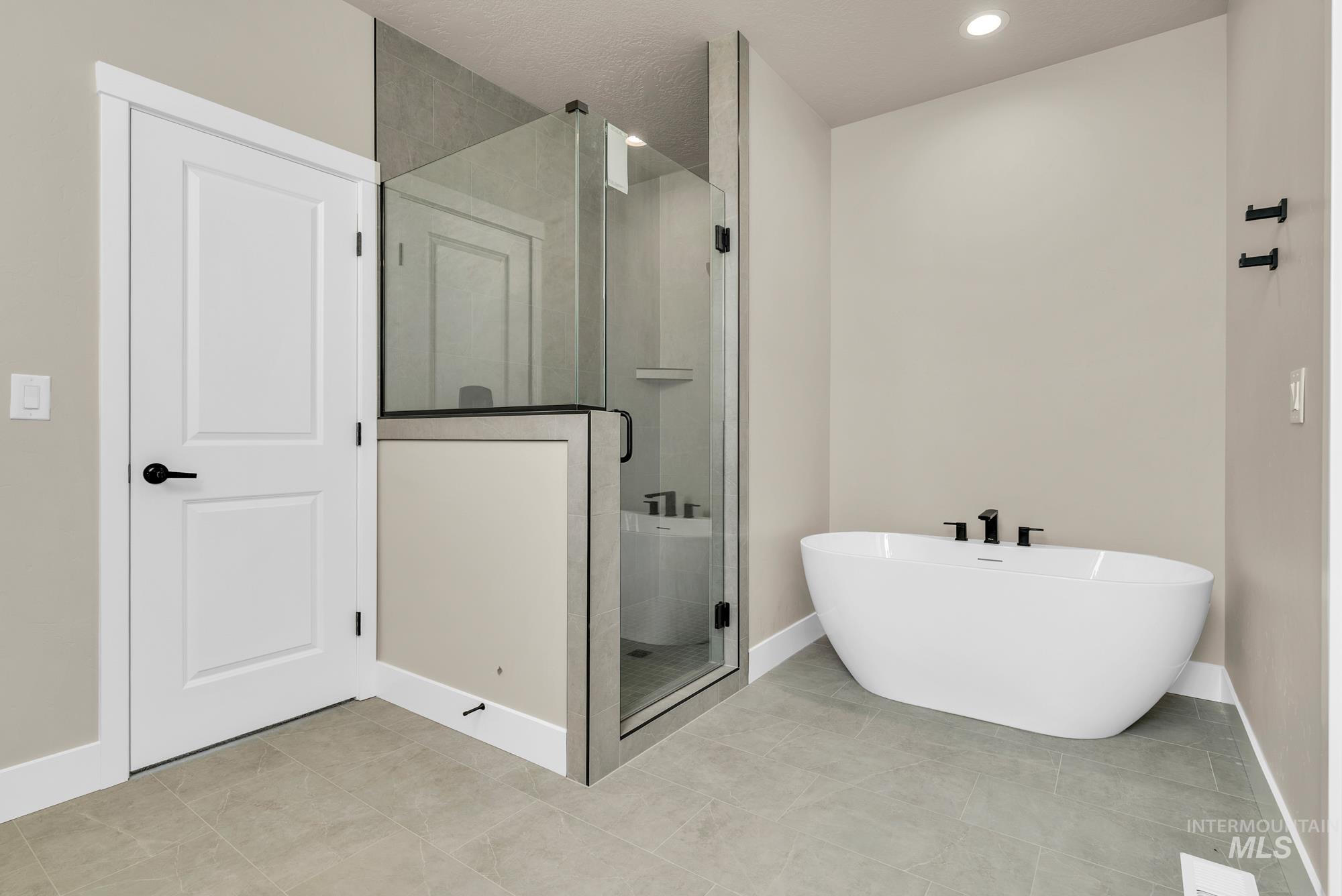 2848 West Jutland Street Meridian, ID 83642 - Photo 16 of 25 Bathroom with a stall shower, a soaking tub, and light tile patterned floors