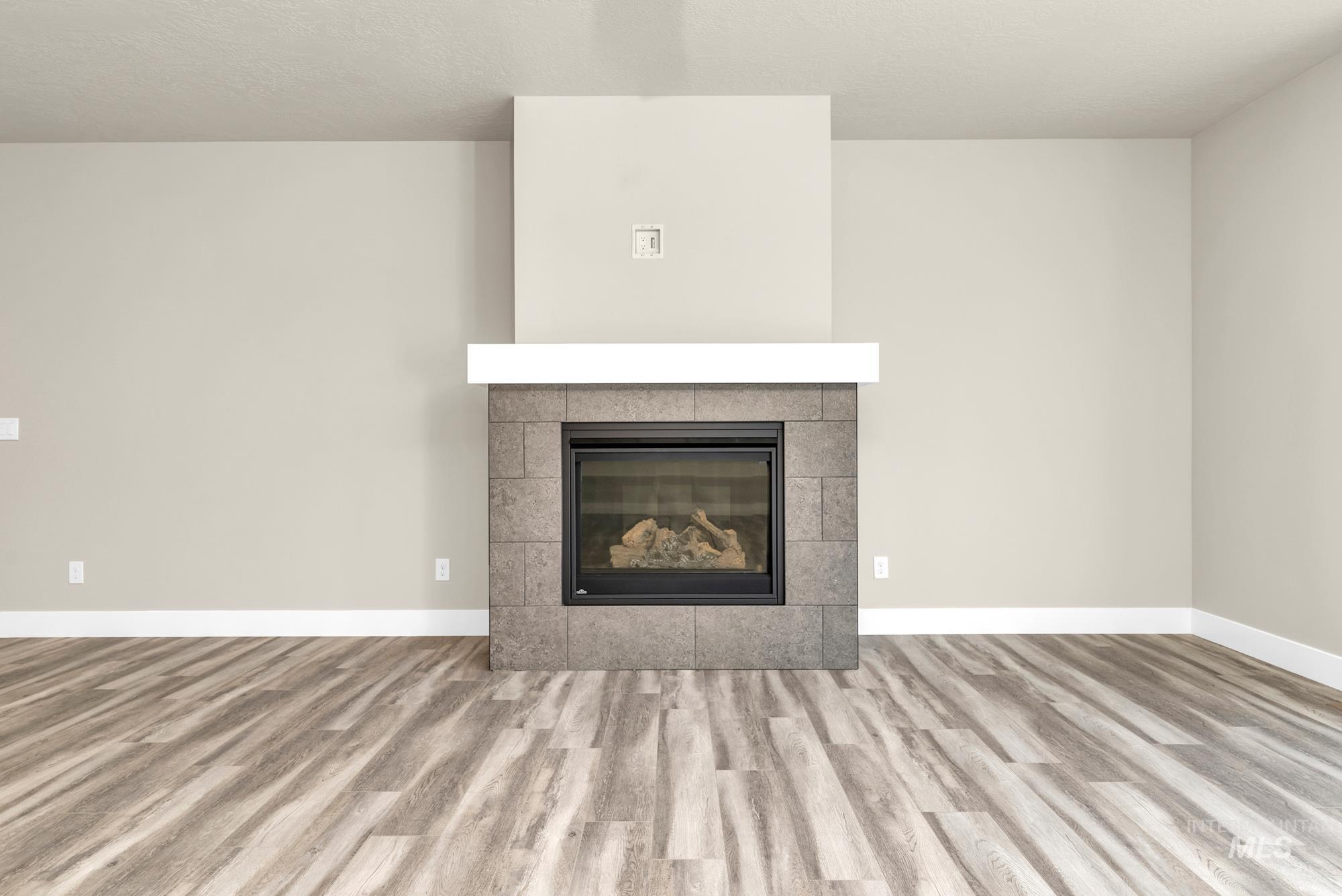 2848 West Jutland Street Meridian, ID 83642 - Photo 5 of 25 Detailed view of wood finished floors, a tile fireplace, and a textured ceiling