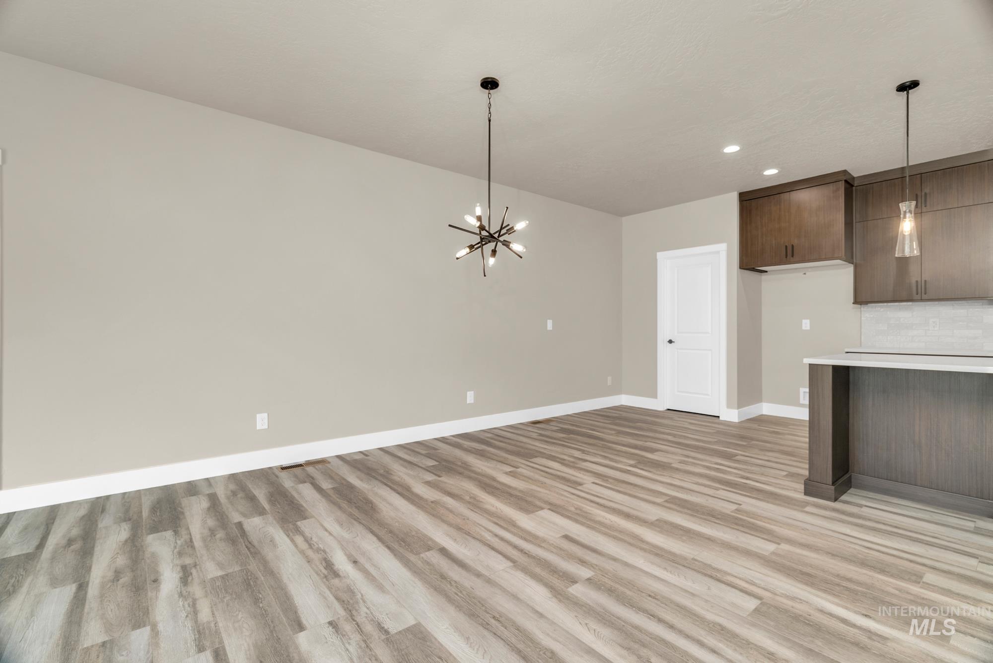 2848 West Jutland Street Meridian, ID 83642 - Photo 9 of 25 Kitchen with light countertops, dark wood finish cabinets, hanging lights, light wood-style flooring, and modern cabinets