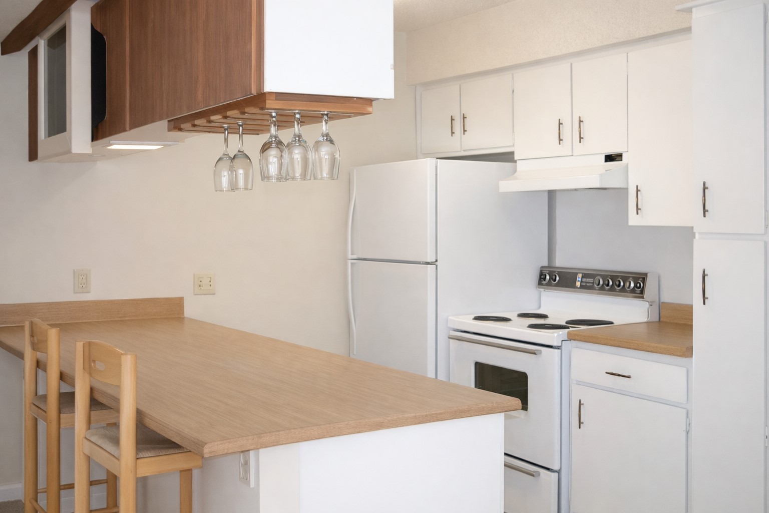 910 Duncan Lane, Unit 52 Austin, TX 78705 - Photo 3 of 9 a kitchen with granite countertop a refrigerator a stove and white cabinets