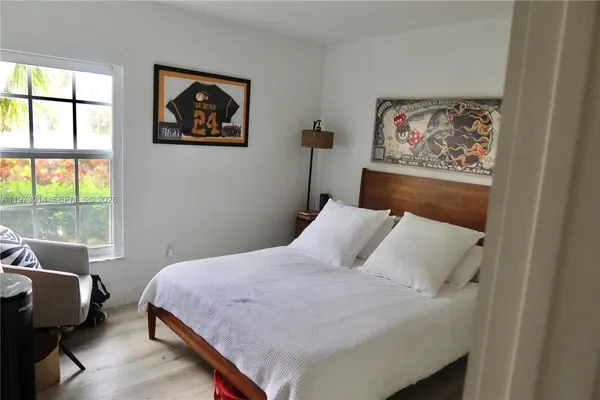 a bedroom with a bed and a painting on the wall