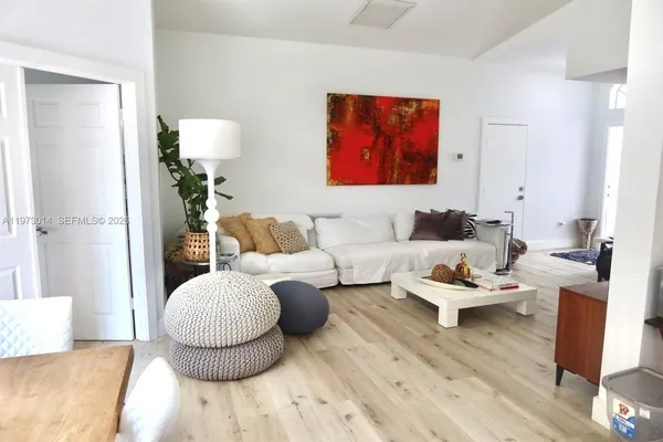 a living room with furniture and wooden floor