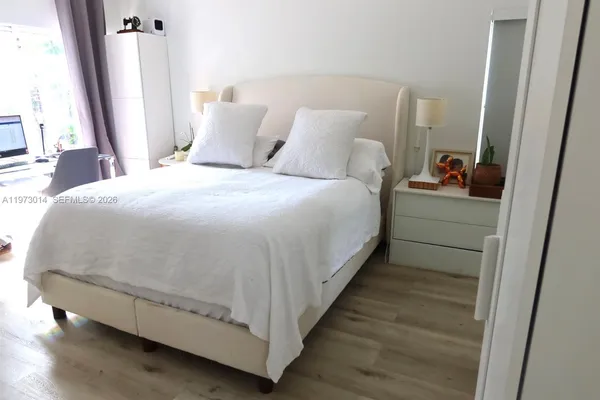 a large bed sitting in a bedroom next to a window