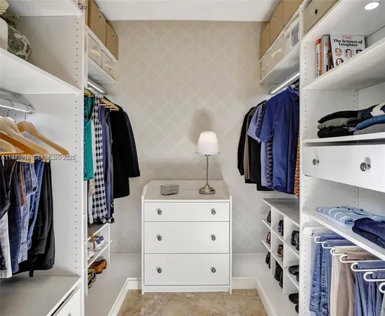 a view of walk in closet with clothes and shoes