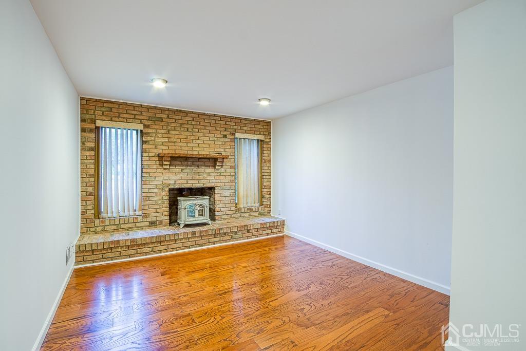 2 Peter Avenue Kendall Park, NJ 08824 - Photo 6 of 19 a view of an empty room with wooden floor and a fireplace