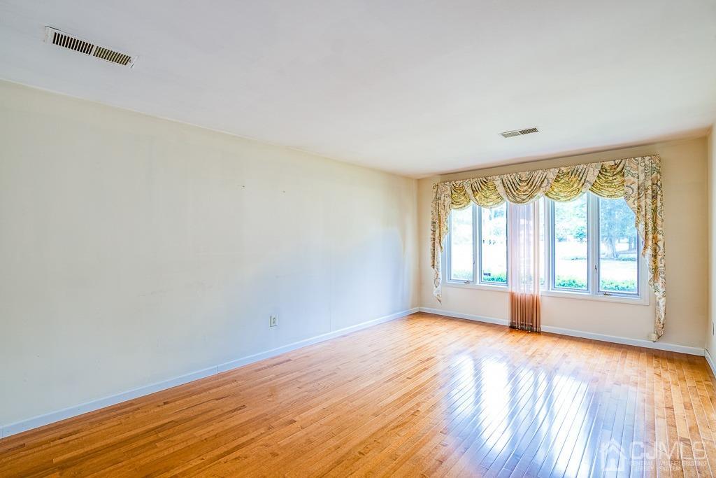 2 Peter Avenue Kendall Park, NJ 08824 - Photo 9 of 19 wooden floor in an empty room with a window