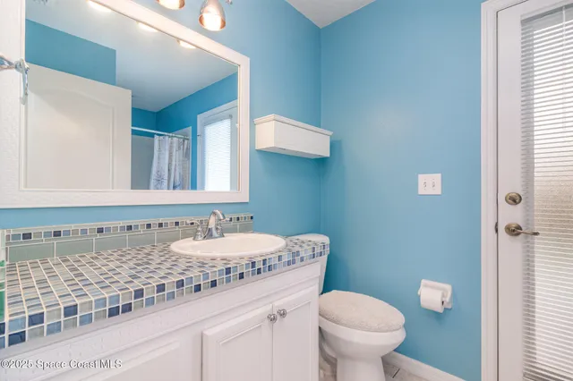 a bathroom with a granite countertop toilet sink and mirror