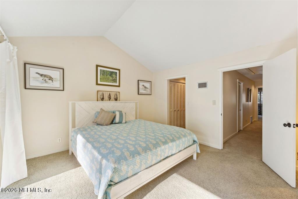 3051 Sea Marsh Road Fernandina Beach, FL 32034 - Photo 17 of 37 a bedroom with a large bed and a chandelier
