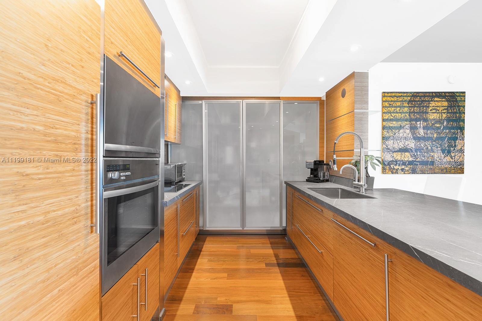 450 Alton Road, Unit 3303 Miami Beach, FL 33139 - Photo 6 of 35 a kitchen with stainless steel appliances granite countertop a sink and a refrigerator