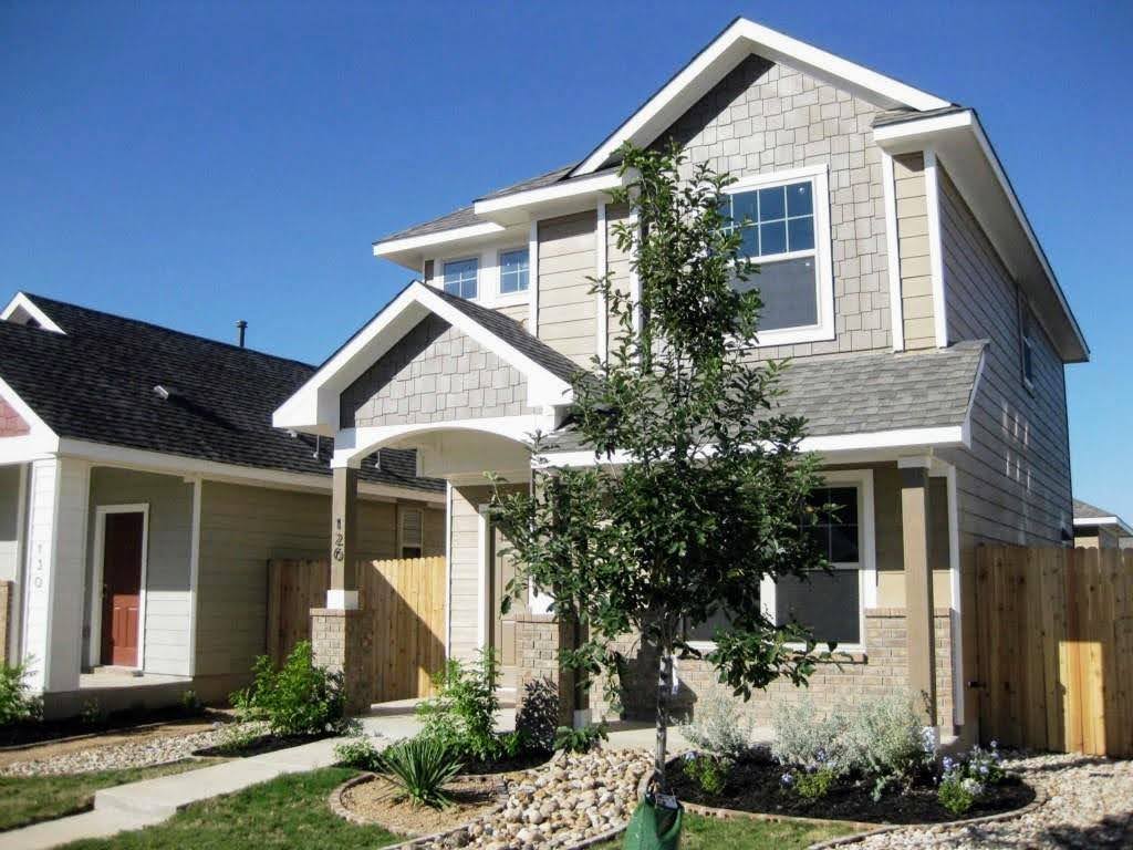 a front view of a house with a yard and potted plants