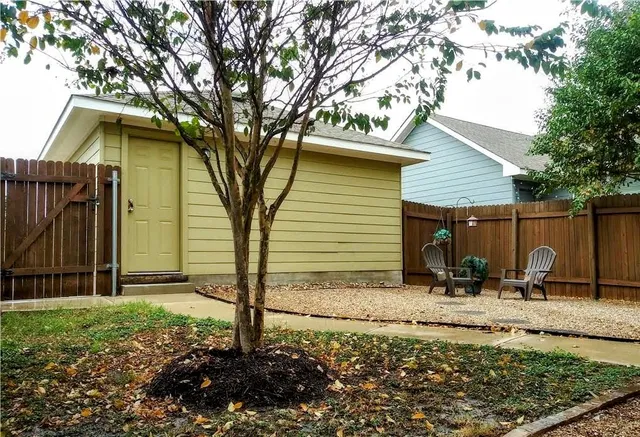 a backyard of a house with plants and tree