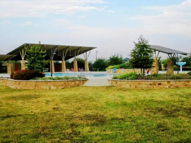 a house view with swimming pool in front of it