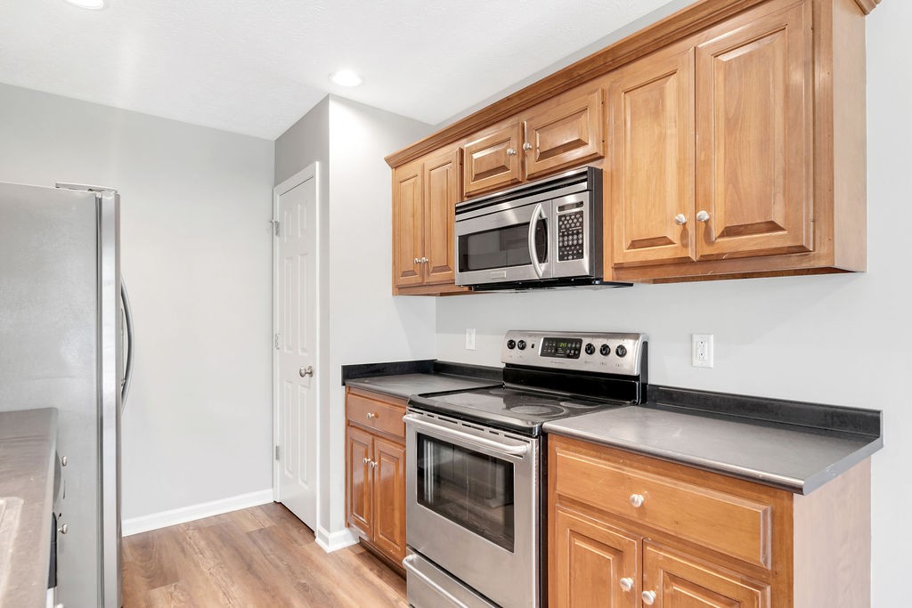 165 Foxrun Springfield, TN 37172 - Photo 22 of 62 a kitchen with stainless steel appliances granite countertop a stove a microwave and a refrigerator