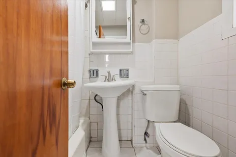 a white toilet sitting next to a bathroom sink