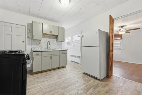 a kitchen with a refrigerator sink and cabinets