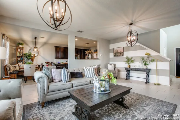 a living room with couches coffee table and kitchen view