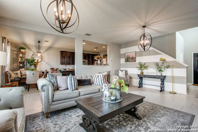 a living room with couches coffee table and kitchen view