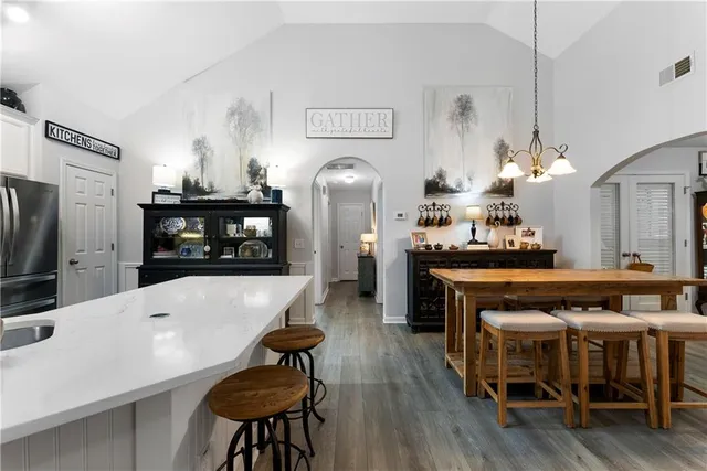 a kitchen with stainless steel appliances a dining table chairs and chandelier