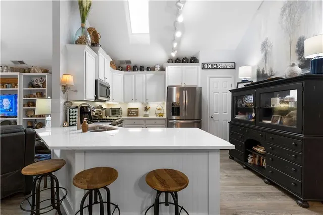 a kitchen with stainless steel appliances a table chairs and a refrigerator