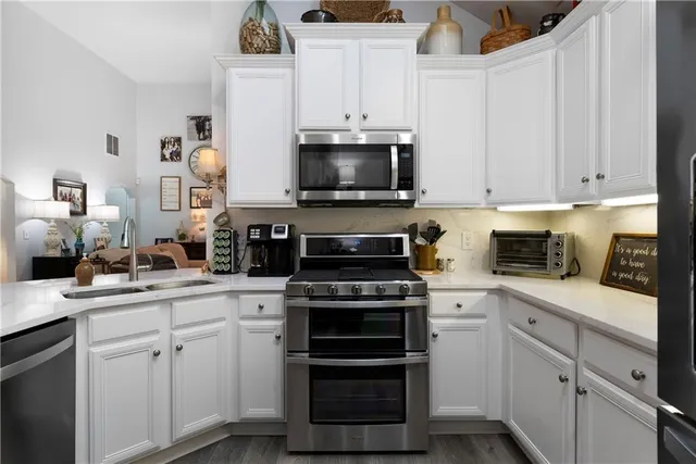 a kitchen with white cabinets and appliances