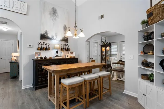 a dining hall with stainless steel appliances kitchen island a table and chairs