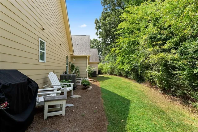 a view of a patio with table and chairs with wooden fence and plants